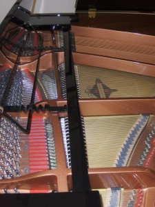 Photo of inside of baby grand piano.